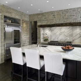 stone wall with white kitchen island white chairs dark hardwood floor kitchen remodel